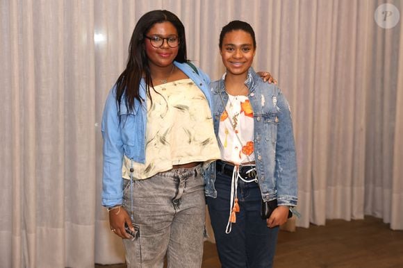 Laura e Maria estavam vestindo calças jeans, blusas estampadas, jaquetas e tênis - um estilo confortável, jovem e descolado para o show
