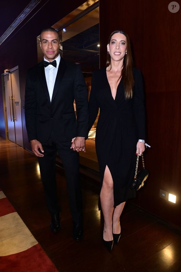 Thiago Oliveira e Bruna Matuti apostaram em produções pretas para o evento, com ele de terno e gravata borboleta e ela com um vestido de decote profundo e fenda