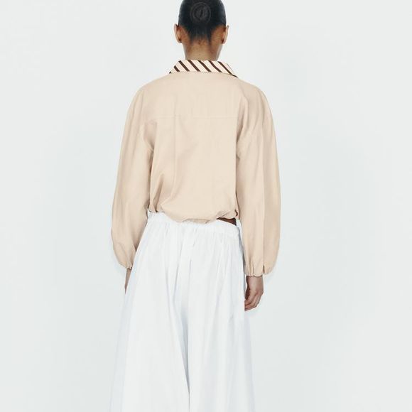 Com cintura alta e modelagem ampla, a saia midi branca da Zara promete dominar os looks femininos mais refinados da temporada