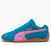 O Speedcat OG, da PUMA, ganha destaque pela combinação de azul predominante com uma faixa rosa que remete ao vestido de Bloom, personagem de Winx, criando um ponto de cor para transformar produções básicas