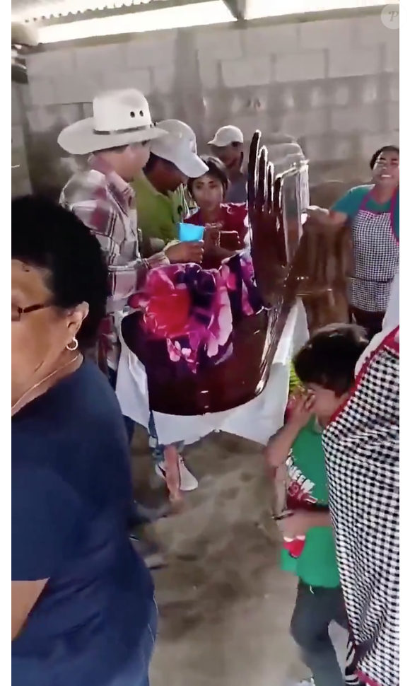 No vídeo, a jovem aparece sentada no caixão enquanto é amparada por pessoas presentes, que a dão água e a ajudam a levantar do caixão