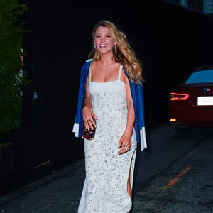 Sobre os ombros, um jaquetão jeans estilo chore coat escuro com mangas e gola brancas — um contraponto moderno ao romantismo do vestido.