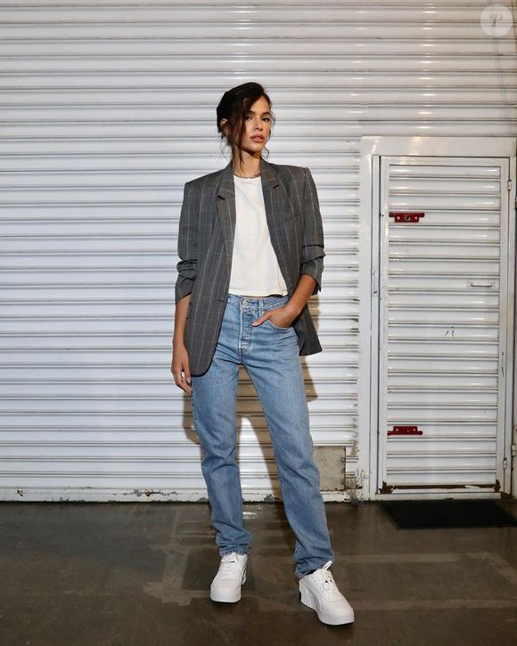 Proposta descontraída de Bruna Marquezine tem calça jeans, com tênis branco para descontrair, além de blazer risca de giz com ombreiras mais alongado