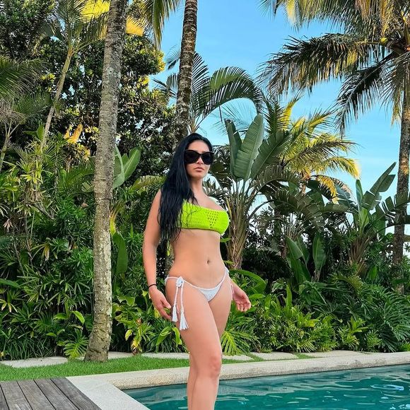 Simaria aparece na beira da piscina. A estrela traja um biquíni verde, na parte de cima, e branco embaixo