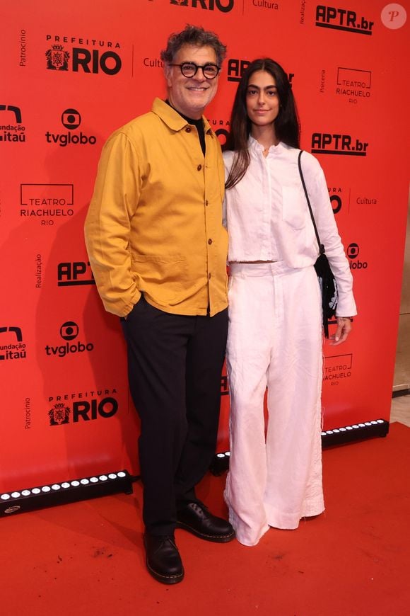 Du Moscovis (com a filha, Sofia): O ator veste uma jaqueta de sarja amarela com botões frontais sobre uma blusa preta de gola alta, combinada com calça de alfaiataria escura e sapatos pretos estilo derby. Sofia aposta em um conjunto minimalista todo branco de linho, composto por camisa de botões levemente amassada e calça pantalona de cintura alta