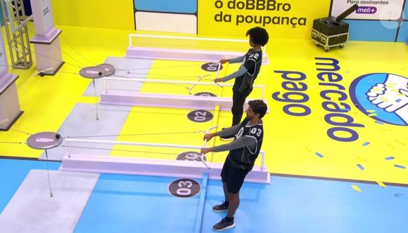 Prova do Líder e de resistência do BBB 26: duplas precisam segurar barras de ferro que estão ligadas a um prato, que tem um imã. É proibido que haja o toque no chão