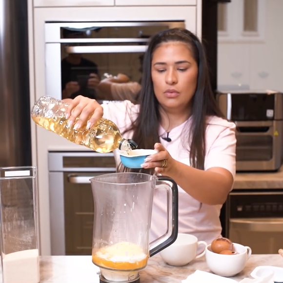 Para começar, acrescente no liquidificador os ovos, o iogurte, o óleo, o queijo parmesão e o açúcar