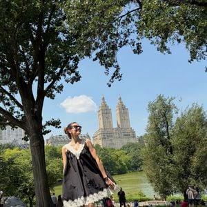 Para o passeio em Nova York, Camila Queiroz apostou em um vestido preto com detalhes de renda creme, unindo uma proposta confortável a elementos sofisticados