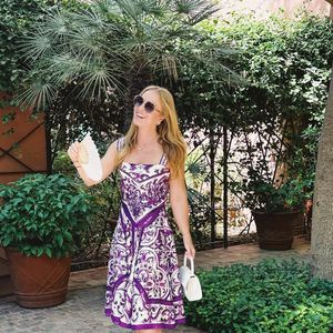 Outro look marcante foi o conjunto de blusa e saia mídi com fundo branco e estampa de arabescos em roxo, uma referência direta ao estilo e à arquitetura local.