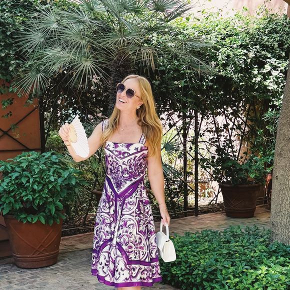 Outro look marcante foi o conjunto de blusa e saia mídi com fundo branco e estampa de arabescos em roxo, uma referência direta ao estilo e à arquitetura local.