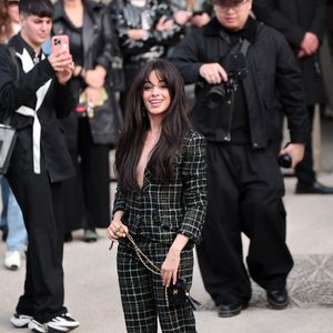 Camila Cabello em look xadrez preto e salto durante a Semana de Moda de Paris 2025.