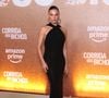 Isis Valverde aposta na elegância minimalista com um vestido longo preto de silhueta ajustada ao corpo, destacando decote frente única transpassado no pescoço e capuz fluido caindo suavemente pelas costas