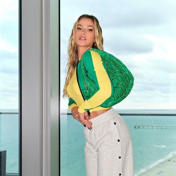 Andressa Suita apostou em um look completo dentro da estética brasilcore. A influenciadora escolheu uma blusa amarela de mangas compridas com detalhes em verde, combinada com bolsa no tom da bandeira do Brasil, calça de moletom cinza com abertura lateral e scarpin branco. O resultado é uma produção moderna e confortável, perfeita para quem deseja torcer com estilo na Copa do Mundo de 2026