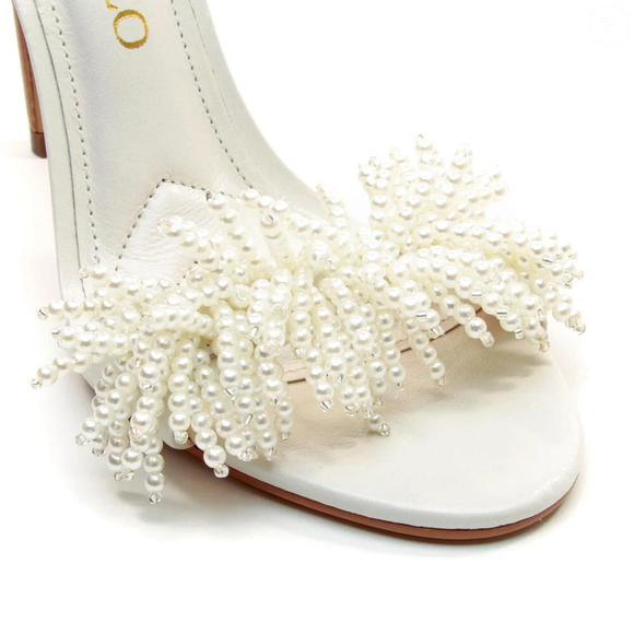 O couro branco e as miçangas da sandália Cecconello criam uma combinação sofisticada que funciona com vestidos fluidos, saias midi e produções para eventos noturnos