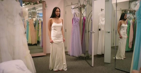 O vestido longo, estilo cami, na cor marfim, chama atenção pela elegância discreta e pelas costas abertas, que remetem diretamente ao estilo dos anos 1990.