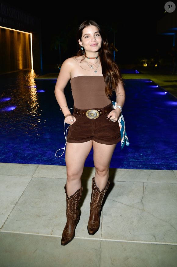 A cantora sertaneja Anna Toledo apostou em look monocromático marrom, com short de camurça e bota western de couro