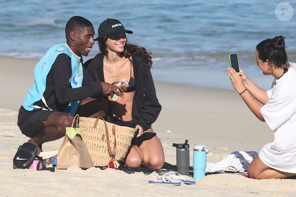 Sorridente, Bruna Marquezine posa com vendedor de praia na semana do aniversário de 30 anos