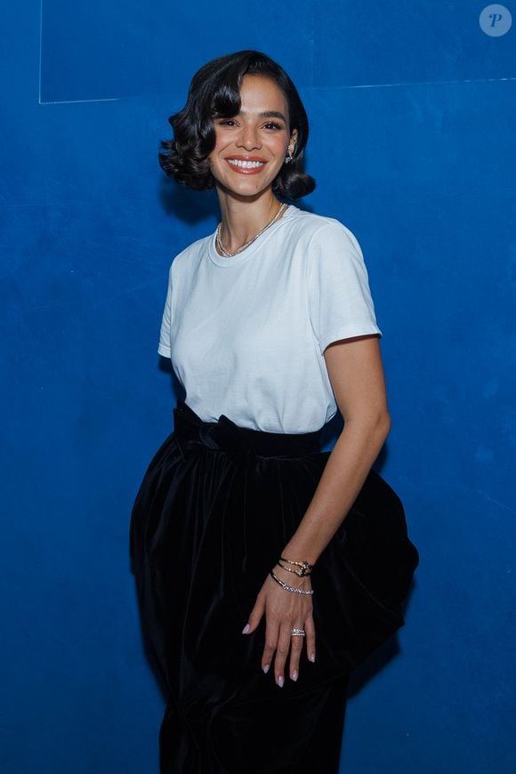 Bruna Marquezine aposta em camiseta branca e saia preta de veludo com volume dramático e laço estruturado na cintura durante evento da Hering em São Paulo