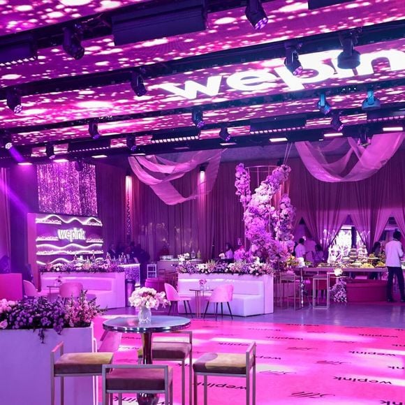 Mesas douradas e arranjos florais completam um dos espaços de convivência da festa