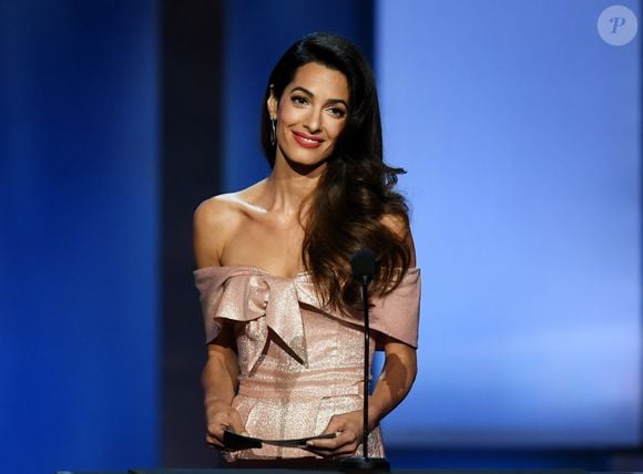 O cabelo castanho e longo de Amal Clooney, aos 47 anos, é puro estilo
