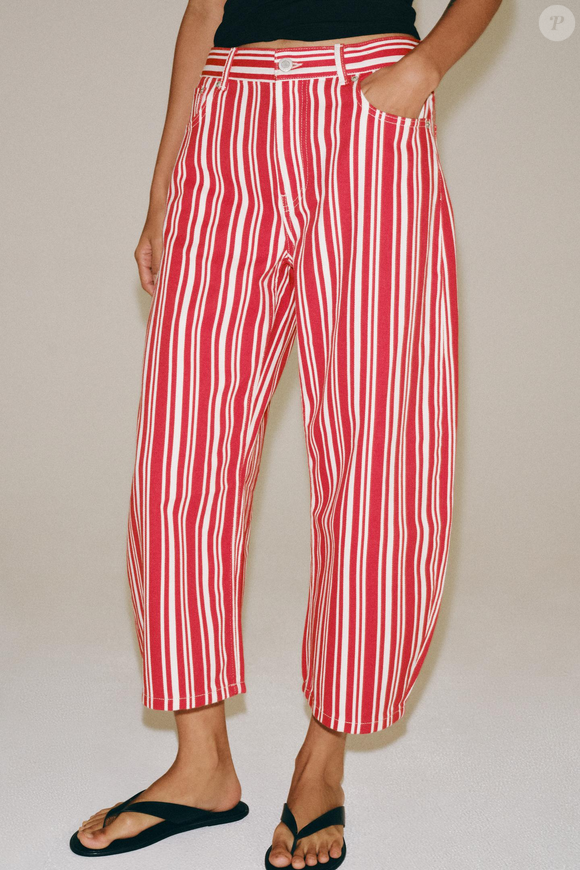 O comprimento Capri, que marcou diferentes momentos da moda, aparece repaginado nesta proposta da Zara. A modelagem balloon ganha listras verticais em vermelho-tomate e cria uma produção que mistura referências retrô com uma silhueta contemporânea. Preço: R$ 319