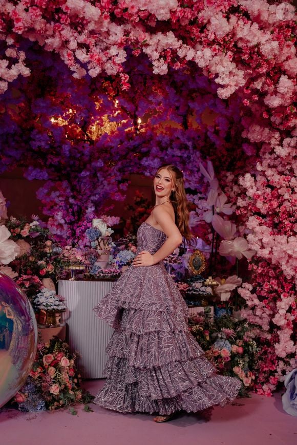 O primeiro vestido de Lorena Queiroz foi um em tom lilás metálico com textura rica e construção arquitetônica. O modelo tomara que caia ganhou destaque pela saia volumosa em camadas de babados estruturados, criando movimento e imponência.