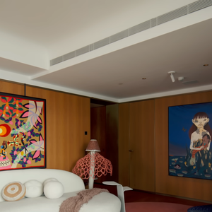 A sala do novo apartamento de Isabeli Fontana e Di Ferrero reúne arte, memória afetiva e personalidade, com sofá da Artefacto voltado para a janela, tapeçaria de Kennedy Bahia e instrumentos musicais, incluindo um violão de 1978 comprado com o segundo salário do pai do cantor