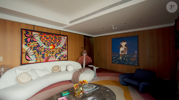 A sala do novo apartamento de Isabeli Fontana e Di Ferrero reúne arte, memória afetiva e personalidade, com sofá da Artefacto voltado para a janela, tapeçaria de Kennedy Bahia e instrumentos musicais, incluindo um violão de 1978 comprado com o segundo salário do pai do cantor