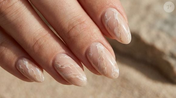 Veios bege e brancos sobre fundo nude criam o efeito mármore, uma leitura sofisticada e artística da manicura neutra