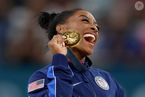 Simone Biles já apareceu com um acessório brilhante no dente, reforçando a presença dos adereços dentários entre celebridades que incorporam detalhes de brilho à estética do sorriso