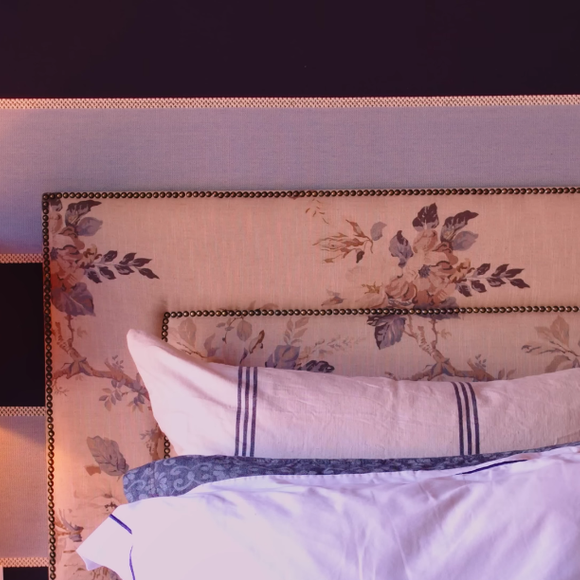 Cabeceira da cama de Chay Suede é feita com estampas florais, as quais também são vistas em diversas áreas da casa