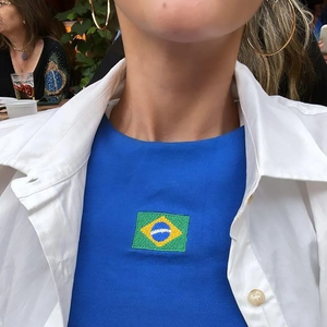 Para quem tem um estilo mais minimalista e prefere uma proposta discreta, fugindo do óbvio verde e amarelo, Bruna Marquezine, apontada como affair de Shawn Mendes, já usou uma blusa com a bandeira do Brasil. A peça é uma excelente opção para incorporar o brasilcore de forma elegante durante a Copa do Mundo de 2026