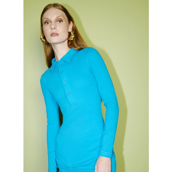 O vestido usado por Yasmin Brunet, que valorizou sua silhueta, possui gola polo, e mangas longas.