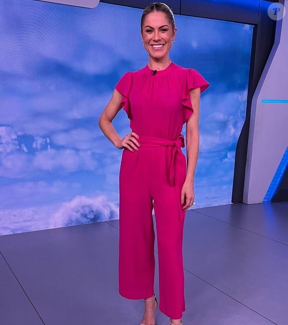 Jornalista da Globo, Jacqueline Brazil apresentou o 'Jornal Hoje' com uma proposta de roupa na cor fúcsia, composta por calça social e blusa de meia manga.