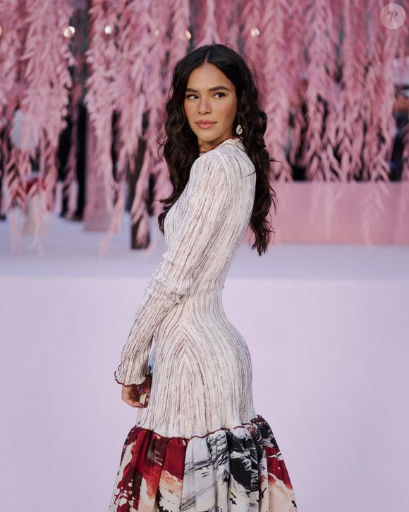 Vestido de Bruna Marquezine tem mangas compridas, com tecido claro e texturizado e com acabamento levemente ondulado nas pontas, que cria uma sensação de movimento e fluidez