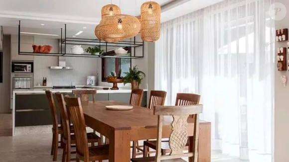 Voltada para a piscina, a sala de jantar é apontada por Ivete como um dos ambientes mais usados da casa. O local reúne mesa ampla, cadeiras confortáveis e luminárias pendentes projetadas para encontros longos com amigos e parentes.