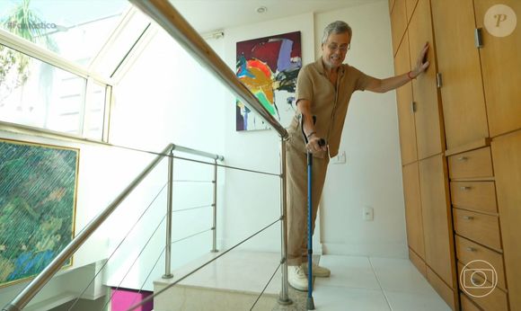 Carlinhos de Jesus se locomove por sua casa com a ajuda de uma muleta