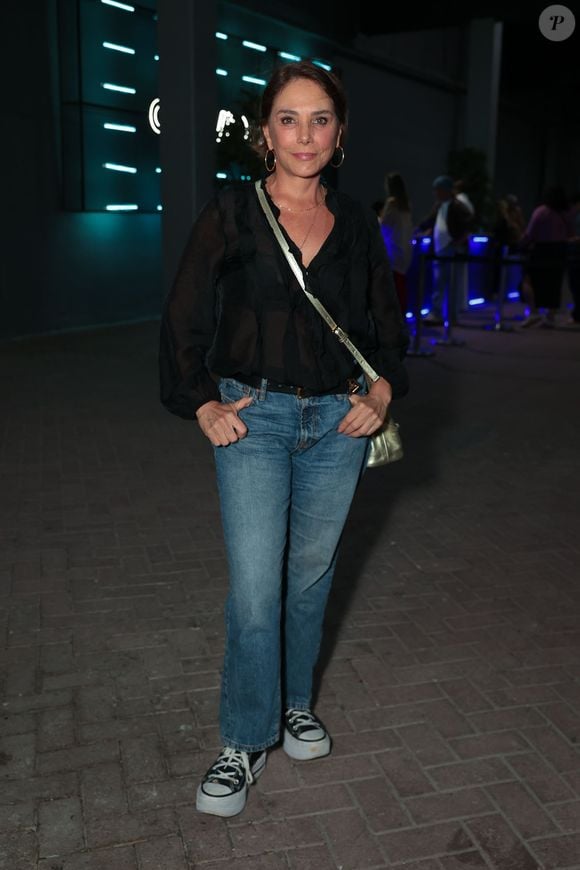 Heloísa Périssé investiu em um look casual chic impecável com uma camisa preta fluida de transparência suave e decote em V. A atriz combinou a peça com calça jeans reta de lavagem clássica e um tênis All Star de plataforma preto e branco. Os acessórios dourados, incluindo uma bolsa transversal metálica e argolas, deram o toque final