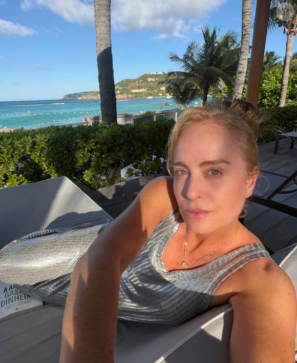 Em uma das fotos, a loira surgiu deitada em uma espreguiçadeira usando um vestido prateado elegante