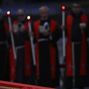 No detalhe: corpo do Papa Francisco sendo velado com velas de religiosos no fundo