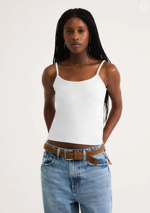 Já a blusa usada pela atriz parece ser uma regata branca fina, bastante versátil. Um modelo semelhante foi localizado na Hering, com decote arredondado e alças finas com elastano, vendido por R$ 59,99
