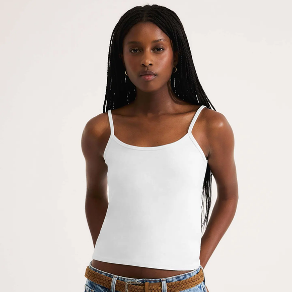 Já a blusa usada pela atriz parece ser uma regata branca fina, bastante versátil. Um modelo semelhante foi localizado na Hering, com decote arredondado e alças finas com elastano, vendido por R$ 59,99