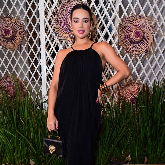 Jordana: a ex-BBB 26 apostou em um vestido longo preto de modelagem fluida com decote halter, trazendo sofisticação minimalista. O visual foi arrematado com uma sandália de tiras cruzadas preta, bolsa de mão estruturada com detalhe dourado e maxibrincos e braceletes também em tom ouro