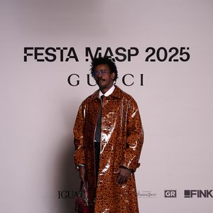 Seu Jorge aposta em trench coat com efeito vinil para evento da Gucci