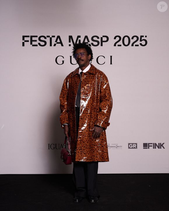 Seu Jorge aposta em trench coat com efeito vinil para evento da Gucci