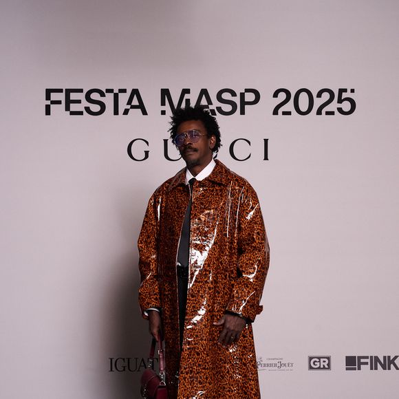 Seu Jorge aposta em trench coat com efeito vinil para evento da Gucci