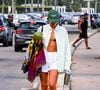 Bruna Marquezine apareceu usando um short branco, camisa comprida verde pastel e um boné verde escuro