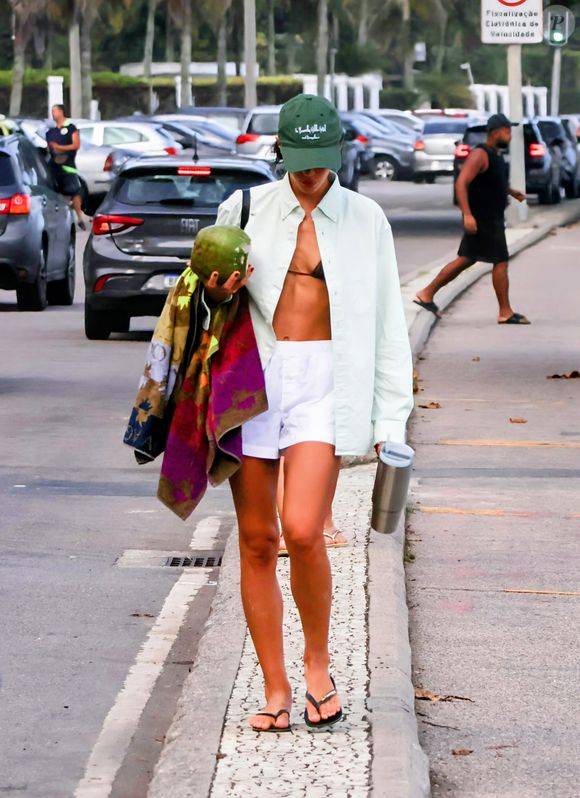 Bruna Marquezine apareceu usando um short branco, camisa comprida verde pastel e um boné verde escuro