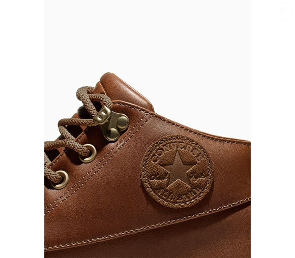 Tyler traz de volta essa silhueta arrojada, veste-a com couro premium e tons quentes de caramelo, e adiciona seus próprios detalhes exclusivos, desde o design da lingueta acolchoada até um pingente com o logotipo le FLEUR*.