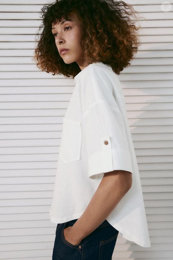 Em branco-marfim, a Camisa Crop em Mistura de Linho com Botões da Zara é confeccionada em mistura de linho e conta com mangas curtas, punhos com tira e fechamento frontal por botões